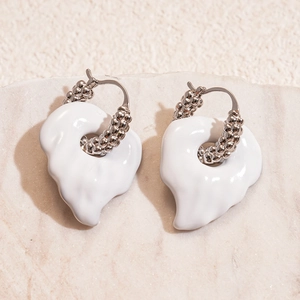 Silver leaf earrings with white enamel charms on textured stone background in a 45-degree view
