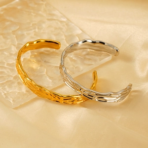 Minimalist irregular gold and silver open bracelets on elegant silk background