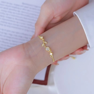 Elegant gold tulip bracelet with cat eye stone and cubic zirconia on female wrist
