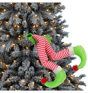 Christmas elf legs in red and white stripes tucked into a snowy Xmas tree with warm lights