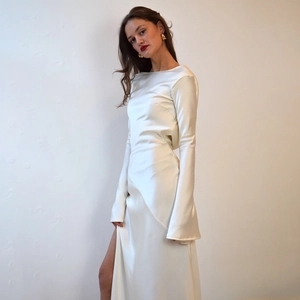 Detail of white satin dress featuring an elegant backless design and high side slit