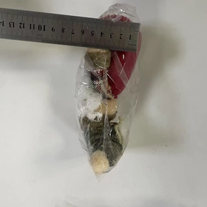 Detailed view of the 14cm Christmas plush doll measuring its size for quality check