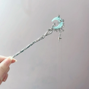 Detail of silver hair stick with moonstone, star charms and flowing metal fringe