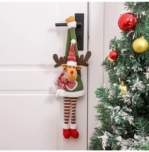 Detailed view of a plush reindeer Christmas door hanger on a white door handle