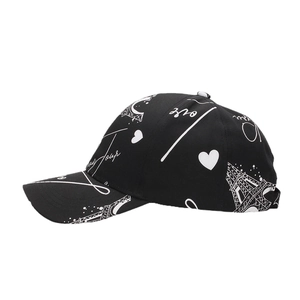 Black baseball cap with white Eiffel Tower graffiti and heart patterns in side view