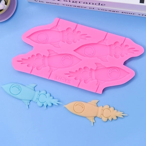 Stampo in silicone rosa a forma di razzo a 4 cavità con lecca-lecca su sfondo blu