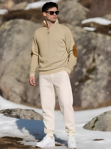 Detail of men's beige knit sweater featuring brown elbow patches and buttoned stand collar