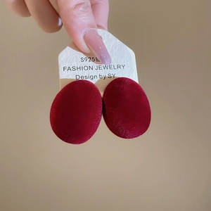 Détail de boucles d'oreilles ovales floquées rouge foncé avec tiges en argent S925