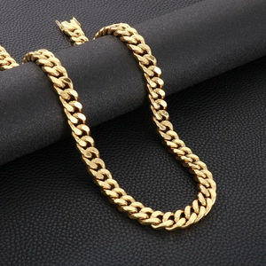 Close-up of 13mm gold Cuban link chain for men on a black leather textured background