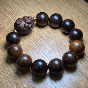 Détail de perles bouddhistes en bois d'agar brun foncé avec une perle de Bouddha gravée