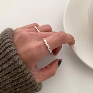 Close-up of minimalist S925 sterling silver twisted and smooth ring set on finger