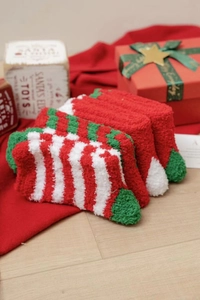 Detail of soft coral fleece Christmas socks in red and green with holiday gift box setup