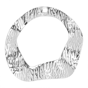 Macro detail of irregular hammered silver pendant charm for DIY stainless steel jewelry