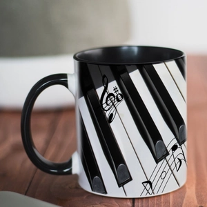 Close-up of ceramic music mug with piano keys and musical notes on a wooden surface