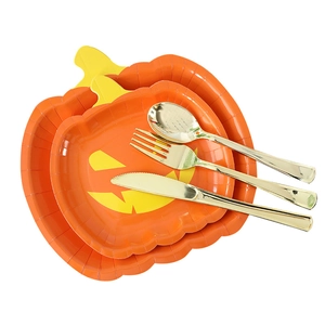 Halloween pumpkin paper plate set with gold plastic cutlery on a white background