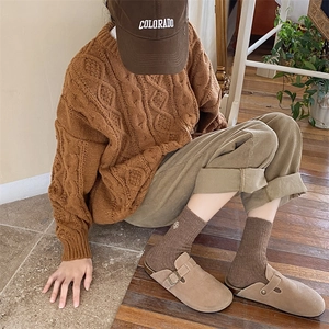 Detail shot of brown knit socks with small embroidery and khaki corduroy pants