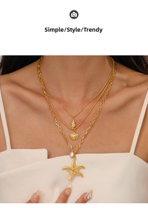 Detailed view of triple-layered gold starfish, shell, and conch pendant necklace on model