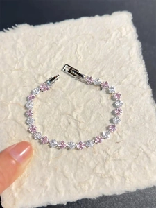 Detailed close-up of a tennis bracelet featuring pink and white zircon stones in silver setting