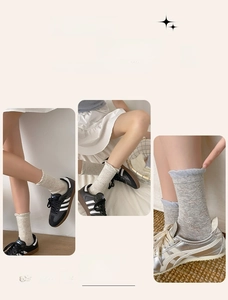 Detail of grey crew socks with butterfly bow jacquard and wavy ruffle trim on the ankle