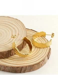 Détail de boucles d'oreilles en C plaquées or 18K avec bords texturés ondulés