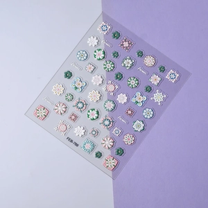 Dettaglio di adesivi nail art 3D a rilievo con motivi di margherite rosa e blu
