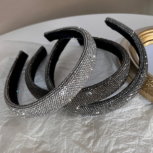 Dettaglio di cerchietti di lusso con strass larghi in argento, canna di fucile e nero
