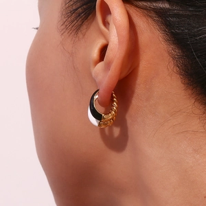 Detail of 18K gold plated teardrop hoop earrings with black and white enamel textures