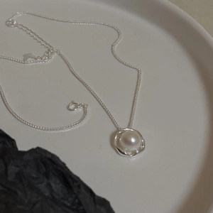 Detail of S925 silver necklace featuring a freshwater pearl in a fluid metal setting