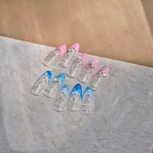 Détails macro de faux ongles faits main avec rubans blancs, perles et touches bleues
