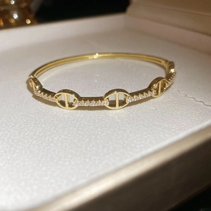 Detailed macro view of gold-plated anchor chain bracelet with sparkling cubic zirconia