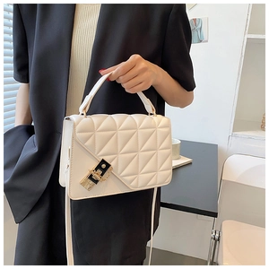 Détail de la texture en cuir blanc matelassé avec fermoir doré pour sac à bandoulière