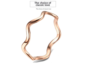 Detailed close-up of a rose gold wavy titanium steel ring with a polished minimalist finish