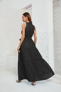 Detail of black halter maxi dress showing layered ruffle hem and textured grid fabric
