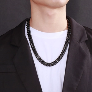 Close-up of a stylish black metal Cuban link necklace worn by a male model