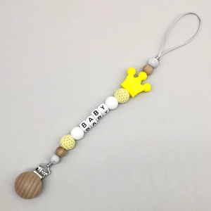 Detail of wooden pacifier clip with silicone crown bead and BABY letter beads