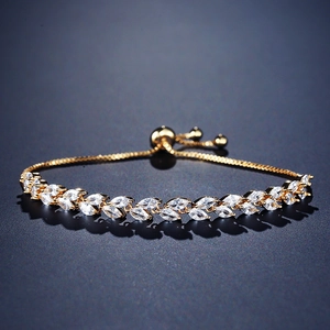 Detalle de pulsera dorada ajustable con circonitas blancas brillantes de corte marquesa