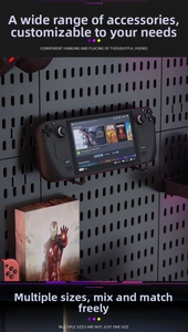 Close-up of black pegboard with metal hooks holding a handheld console in gaming setup