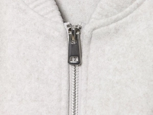 Close-up of high-quality silver metal zipper on soft light gray fleece bomber jacket