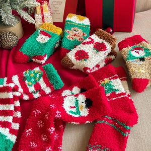 Close-up of thick coral fleece Christmas socks featuring festive Santa and reindeer patterns