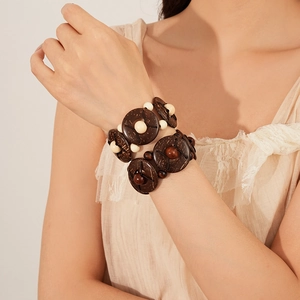 Ethnic double-row coconut shell and wood bead stretch bracelet on a model's wrist