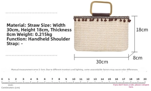 Detailed view of woven straw tote bag with brown pom-pom trim and wooden handles