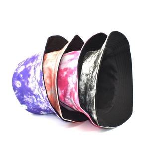 Fashionable tie-dye bucket hats in purple, orange, pink, and grey with reversible black lining