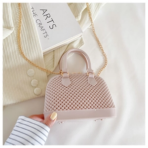 Close-up of pink jelly shell bag with beaded texture and elegant gold chain strap