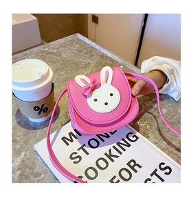 Detail of cute pink rabbit crossbody bag with leather texture and white bunny decoration