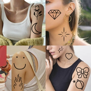Detail of waterproof temporary tattoos with black moon, stars, and smiley face patterns