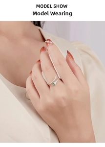 Macro detail of snake ring with green zircon eyes and white stones on model hand