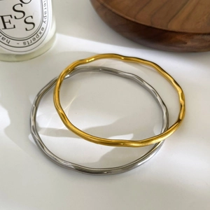 Minimalist 18K gold and silver titanium steel wave bracelets for women displayed in a set