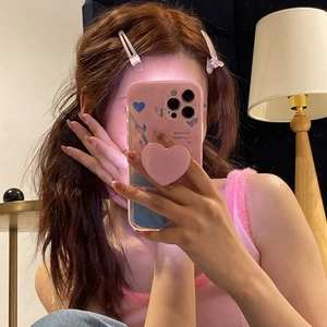 Close-up of pink heart hair clips and matching phone grip in a daily fashion setting