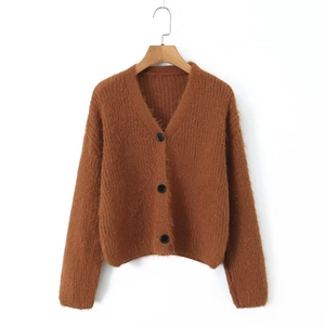 Detail of caramel mohair cardigan with V-neckline and black buttons on white background