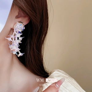Elegant floral drop earrings with aurora petals and white bead core worn by a model